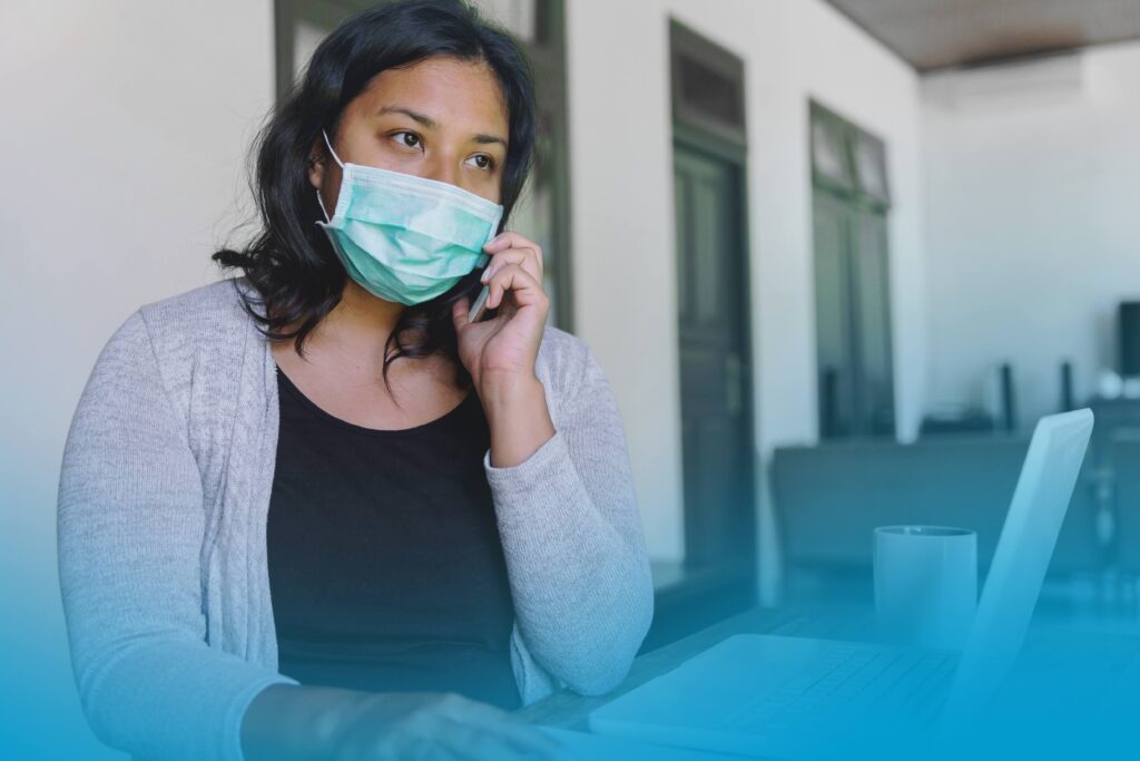 Portrait shot of concerned Asian woman with face mask, listening voicemail message on the phone