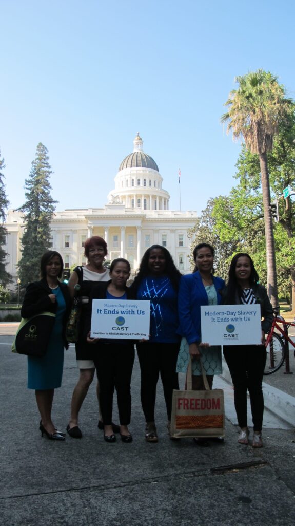 Women holding sign Modern Day Slavery it ends with us