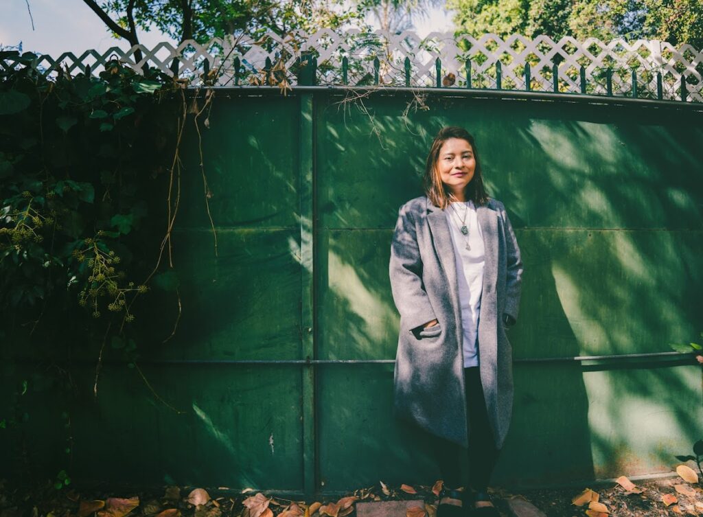 woman standing in front of a green fence
